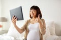 Happy pregnant asian woman with tablet pc at home Royalty Free Stock Photo