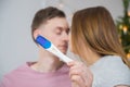 Pregnancy test on background of desfocused young couple. Love, new parents and happy family Royalty Free Stock Photo