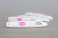 Pregnancy test close-up with a big pink button on a gray background