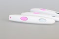 Pregnancy test close-up with a big pink button on a gray background