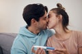 Pregnancy, test and couple kiss in home living room for good news or positive results. Romance, man and pregnant woman Royalty Free Stock Photo