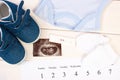 Pregnancy test, ultrasound scan of baby, clothing for newborn and calendar, expecting for baby concept Royalty Free Stock Photo