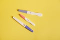 Pregnancy tests with positive result, isolated on yellow background. Planning pregnancy and maternity concept Royalty Free Stock Photo
