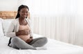 Pregnancy Time. Happy Black Pregnant Woman Sitting On Bed Touching Belly Royalty Free Stock Photo