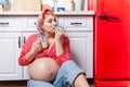 Pregnancy and unhealthy eating concept: pregnant woman eats a tasty doughnut