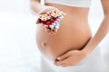 Pregnancy Vitamins And Medications. Pregnant Woman With Pills