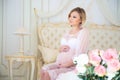 Pregnancy and waiting for baby. Pregnant mother sitting on a bed of roses Royalty Free Stock Photo