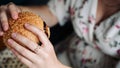 Pregnancy woman burger eating. Hungry pregnant girl biting hamburger. Fast food, people and unhealthy eating concept.