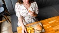 Pregnancy woman burger eating. Hungry pregnant girl biting hamburger. Fast food, people and unhealthy eating concept.