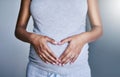 Pregnancy, woman and heart hands on her stomach for love, care and maternity in her house. Bonding, maternal and closeup Royalty Free Stock Photo