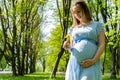 Pregnancy woman walk. Pregnant nature walk. Happy maternity mother in summer park. Baby belly. Pregnancy activity. Royalty Free Stock Photo