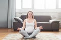 Pregnancy yoga. Beautiful expectant mother doing yoga at home. sitting in lotus Relaxation