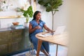 Pregnant African American Woman Using Laptop At Table Working From Home Royalty Free Stock Photo