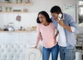 Pregnant African American woman having prenatal contractions, worried husband calling doctor on smartphone Royalty Free Stock Photo