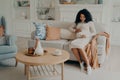 Pregnant afro american woman sitting on couch and spending time at home