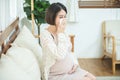 Pregnant asian female use tissue paper close mouth and nose, she cough and feeling fever, pregnancy and people concept - sick