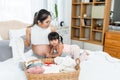 pregnant asian teen mom Pregnant near the time of childbirth Sit and prepare clothes for the upcoming baby. Cute daughter trying Royalty Free Stock Photo