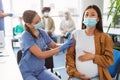 Pregnant Asin Woman Getting Vaccinated Against Covid-19, Doctor Applying Plaster Royalty Free Stock Photo