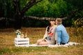 Pregnant beautiful woman with her handsome husband sweetly resting outdoors in the autumn on picnic. Royalty Free Stock Photo