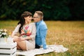 Pregnant beautiful woman with her handsome husband sweetly resting outdoors in the autumn on picnic. Royalty Free Stock Photo
