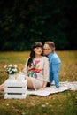 Pregnant beautiful woman with her handsome husband sweetly resting outdoors in the autumn on picnic. Royalty Free Stock Photo