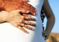 Pregnant belly with hands of future parents in love. Maternity concept.  on white background Royalty Free Stock Photo