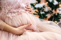 Pregnant belly in christmas, christmas tree on background