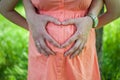 Pregnant Belly with fingers Heart symbol.