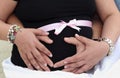 Pregnant belly with mother and father hands around Royalty Free Stock Photo