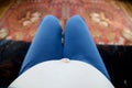 Pregnant belly of sitting woman relaxing on sofa. selfie view from above. Expecting baby birth in third trimester for being mother