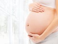 Pregnant belly of a young woman in a light interior Royalty Free Stock Photo