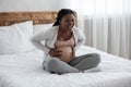 Pregnant black lady having labor contractions at home, suffering from belly ache Royalty Free Stock Photo