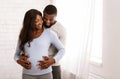 Pregnant afro woman and her husband cuddling at home Royalty Free Stock Photo