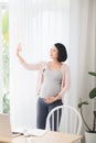 Pregnant blogger takes selfie on the phone. Pregnant freelancer in the office with the phone