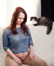 Pregnant blonde woman relaxing on sofa with cat Royalty Free Stock Photo