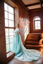 Pregnant bride blonde is preparing to become a mother and wife. Long turquoise dress on a girl body. Curly hair and a beautiful Royalty Free Stock Photo