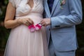 Pregnant bride with the groom holding small pink shoes on their wedding day Royalty Free Stock Photo