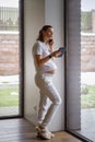 Pregnant business woman in the last stage of pregnancy solves problems while at home