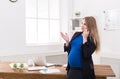 Pregnant business woman talking on phone at office Royalty Free Stock Photo