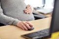 Pregnant businesswoman with computer at office Royalty Free Stock Photo