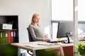 Pregnant businesswoman with computer at office Royalty Free Stock Photo