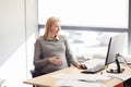 Pregnant businesswoman with computer at office Royalty Free Stock Photo