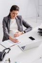 pregnant businesswoman writing in notebook near Royalty Free Stock Photo