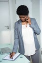 Pregnant businesswoman writing on notebook Royalty Free Stock Photo