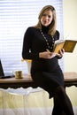 Pregnant businesswoman writing notes by desk Royalty Free Stock Photo