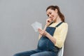 Pregnant cheerful woman holding ultrasound scans