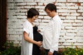 Pregnant couple comparing the size of their big belly, maternity concept portrait, on grey background Royalty Free Stock Photo
