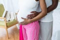 Pregnant couple embracing in bedroom