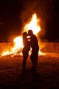 Pregnant couple in front of a giant fire