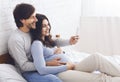 Pregnant couple relaxing with smartphone on bed at home Royalty Free Stock Photo